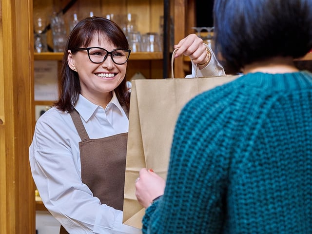 Woman Restaurant Worker Handing Bag.jpg