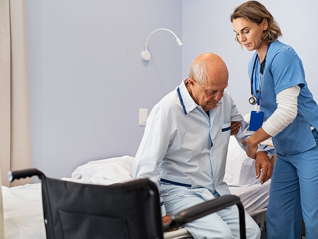 nurse helping patient into wheelchair.jpg