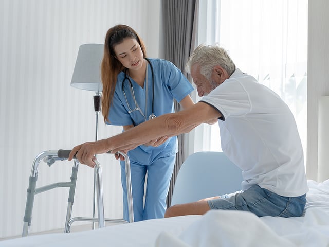nurse helping elderly man walker.jpg