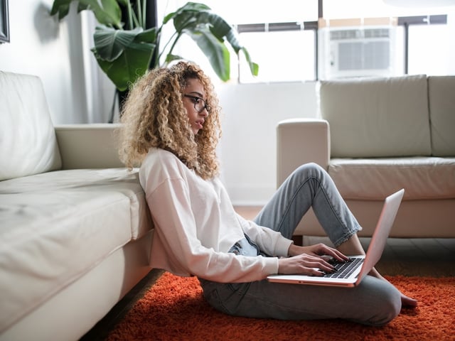 curly haired girl laptop white sweater.jpg